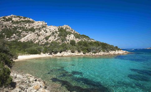 Azurblaues Wasser umgibt die Küste am Capo d'Orso.